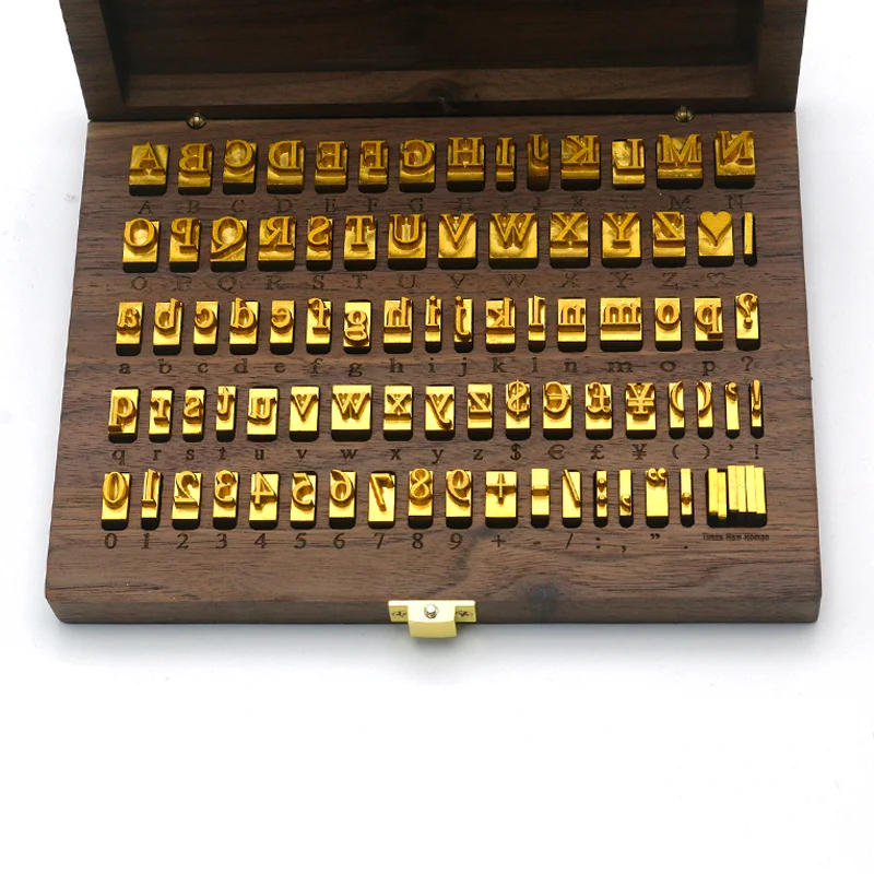 Full set of WT Brand CNC-engraved brass alphabet and number movable type for hot stamping, arranged neatly in a wooden storage box.