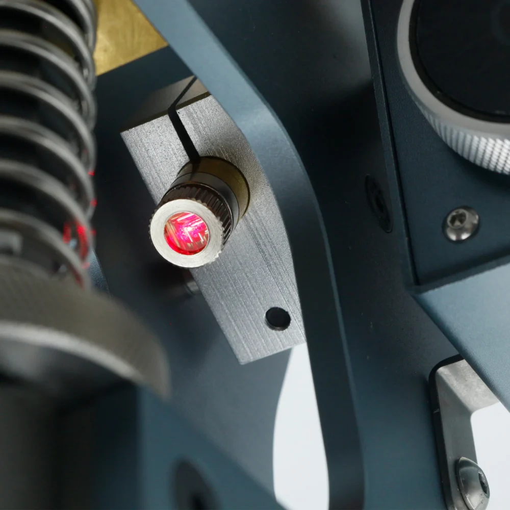 Close-up of ZHENGFEI ELC-01 red laser positioning module for zero-error hot stamping alignment.
