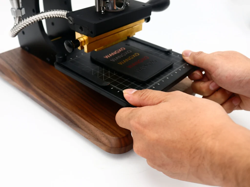 Hands adjusting the worktable of a ZHENGFEI EC-17 hot stamping machine for precise alignment.