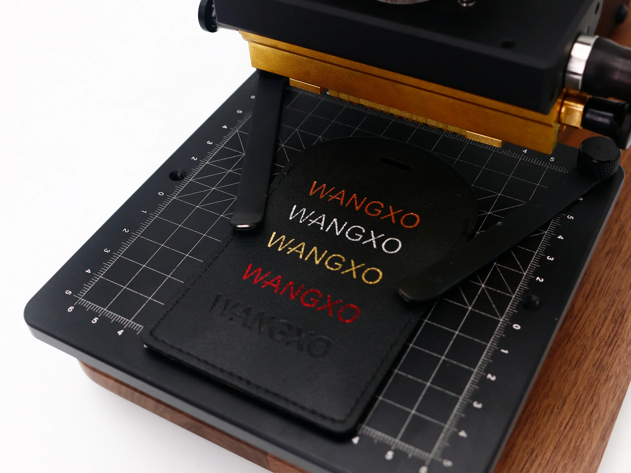 Close-up of ZHENGFEI EC-17 stamping machine worktable with grid alignment and multi-color foil samples.
