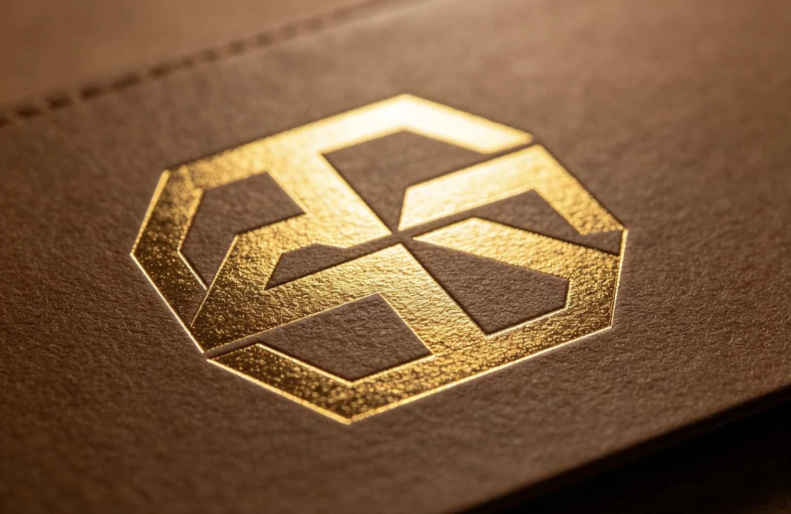 Large solid geometric hexagon logo gold foil stamped on brown leather with ZHENGFEI custom CNC brass mold, even full solid coverage.