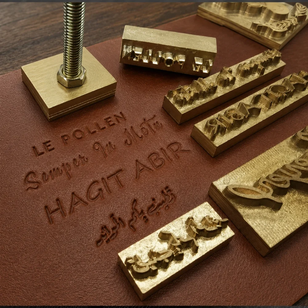 Latin & Arabic script brass text dies paired with blind embossed finished brown leather sample showing clear multi-language stamping results.