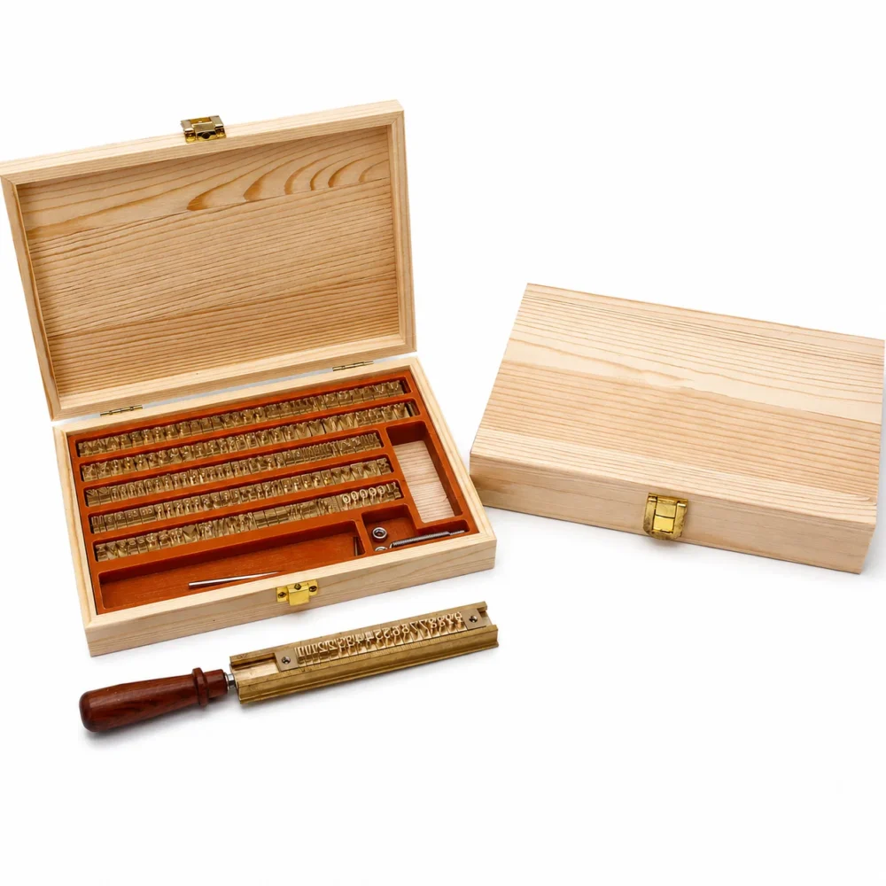 Movable brass letter set in light pine wooden case equipped with brass type holder and stamping accessories