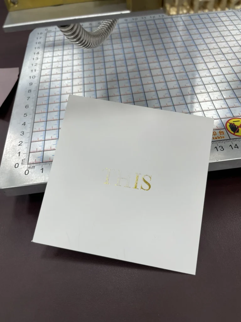 WT-90SK test at 100°C showing broken gold foil strokes on glossy cardstock