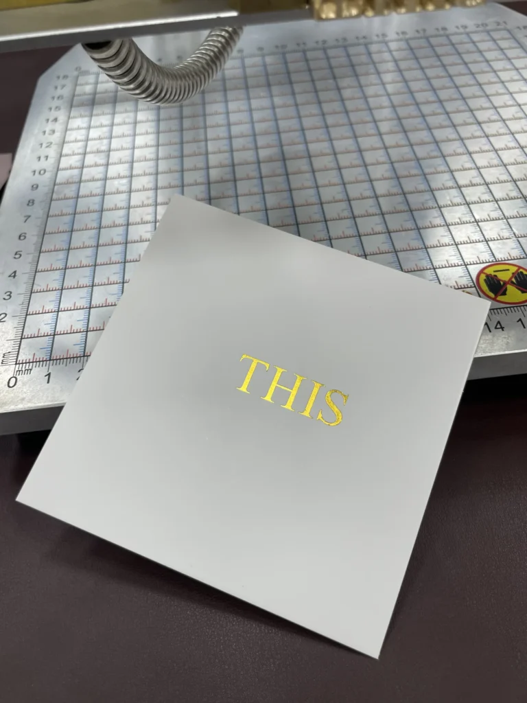 WT-90SK test at 110°C showing complete gold foil lettering on glossy cardstock